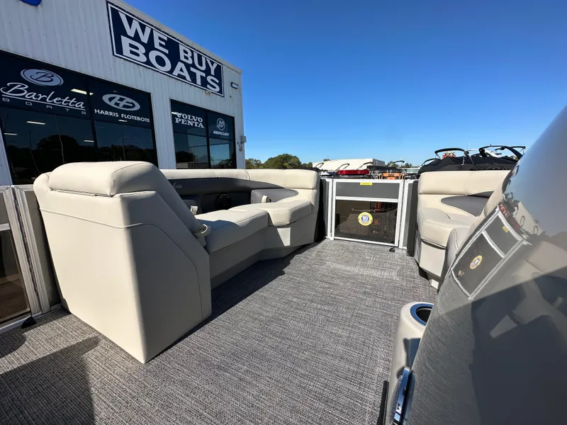 Slide: The Image of 2024 Barletta A20UC pontoon boat interior at dealership, showcasing seating and deck. - 17