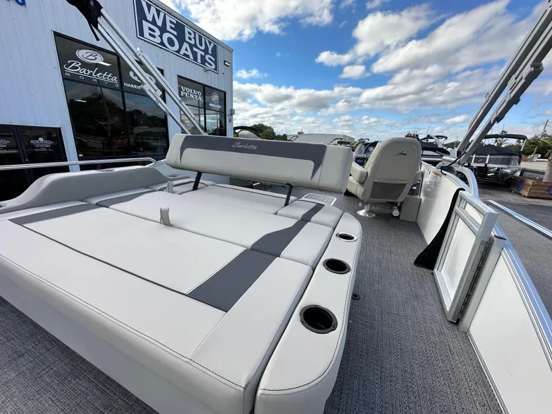 Slide: The Image of 2024 Barletta A22UC pontoon boat with spacious seating, displayed at a dealership. - 13