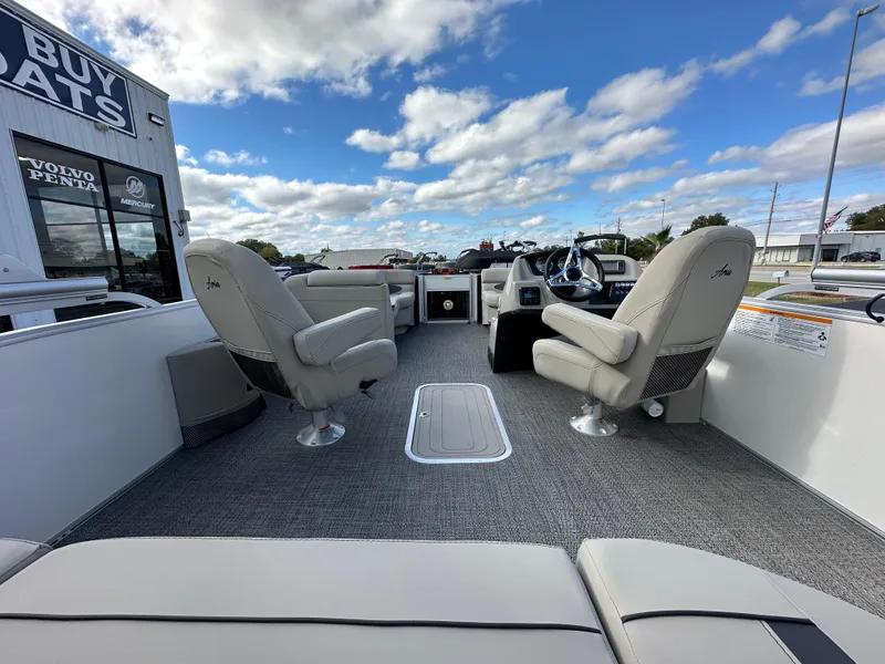 Slide: The Image of 2024 Barletta A22UC boat interior with plush seating and modern dashboard under a blue sky. - 14