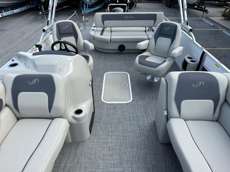 Slide: The Image of 2024 Barletta A22UC boat interior with gray seating and steering console. - 22