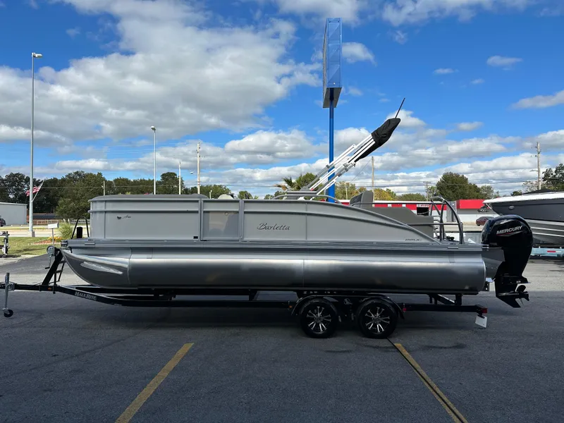 Slide: The Image of 2024 Barletta A22UC pontoon boat on trailer under blue sky. - 6