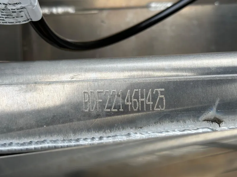 Slide: The Image of 2025 Barletta A22UC boat hull identification number engraved on metal surface. - 25