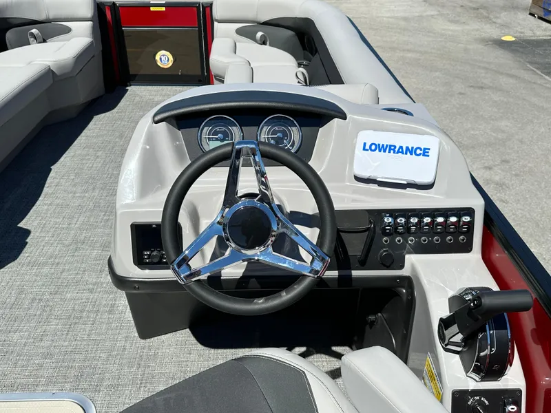 Slide: The Image of 2025 Barletta A24UC boat dashboard with steering wheel and Lowrance navigation system. - 14