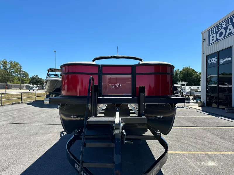 Slide: The Image of 2025 Barletta A24UC pontoon boat in vibrant red at dealership. - 3