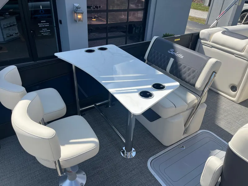 Slide: The Image of Luxurious seating area on 2025 Barletta L25UEA boat with table and cup holders. - 18