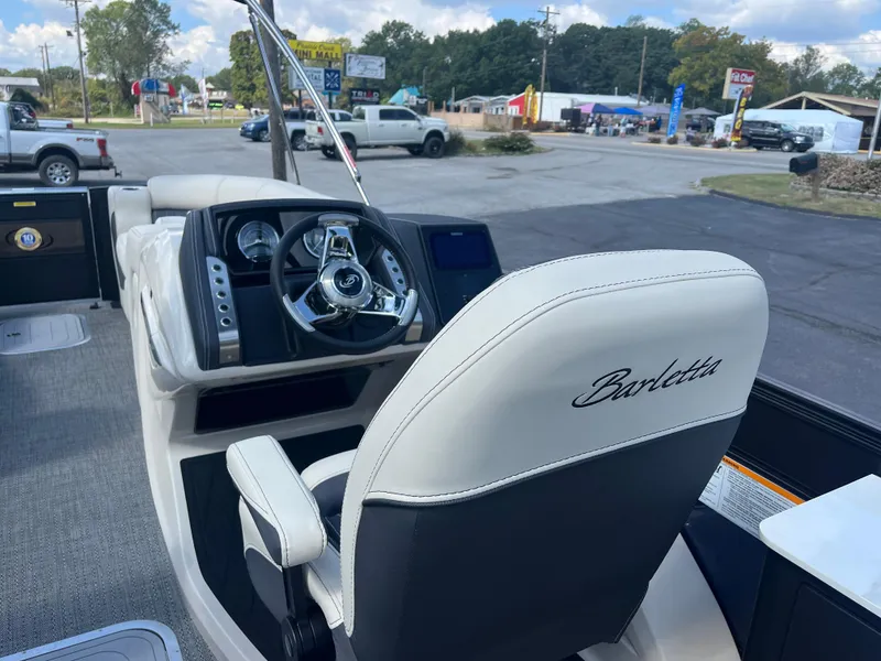 Slide: The Image of 2025 Barletta L25UEA boat interior with steering wheel and captain's chair. - 23