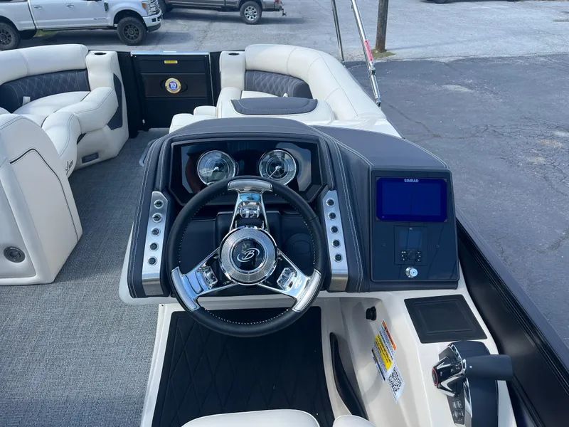 Slide: The Image of 2025 Barletta L25UEA boat dashboard with steering wheel and control panel. - 24