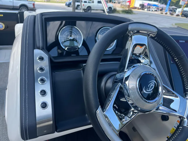 Slide: The Image of 2025 Barletta L25UEA boat dashboard with chrome steering wheel and gauges. - 25