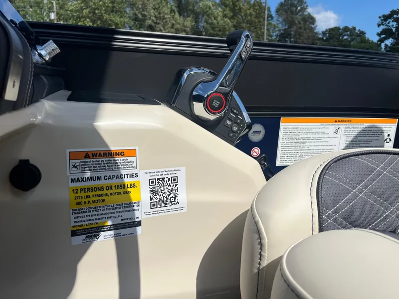 Slide: The Image of 2025 Barletta L25UEA boat dashboard with capacity warning labels and control lever. - 28