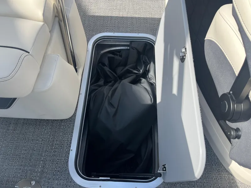 Slide: The Image of Open storage compartment in 2025 Barletta L25UEA boat with black cover inside. - 30
