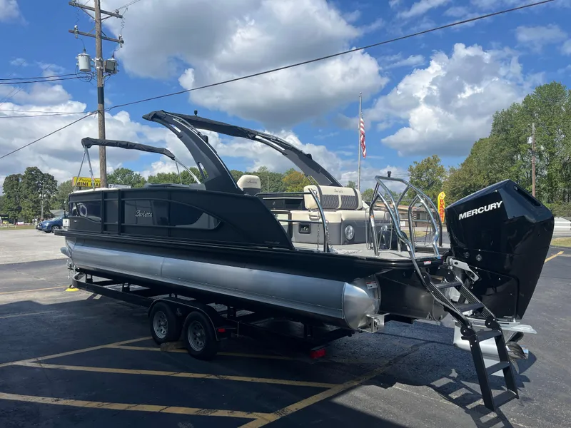 Slide: The Image of 2025 Barletta L25UEA pontoon boat with Mercury engine on trailer, under blue sky. - 5
