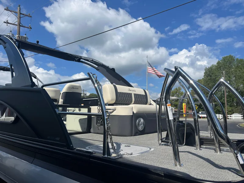 Slide: The Image of 2025 Barletta L25UEA pontoon boat with elegant seating and American flag, under blue sky. - 8