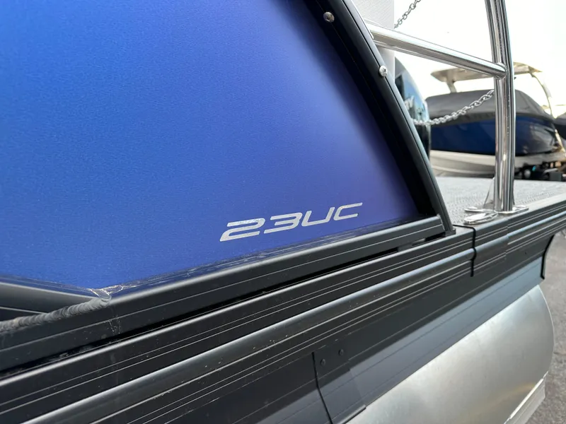 Slide: The Image of 2024 Barletta X23UC pontoon boat with blue paneling and sleek design. - 10