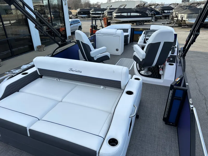 Slide: The Image of 2024 Barletta X23UC pontoon boat interior with plush seating and modern helm. - 13