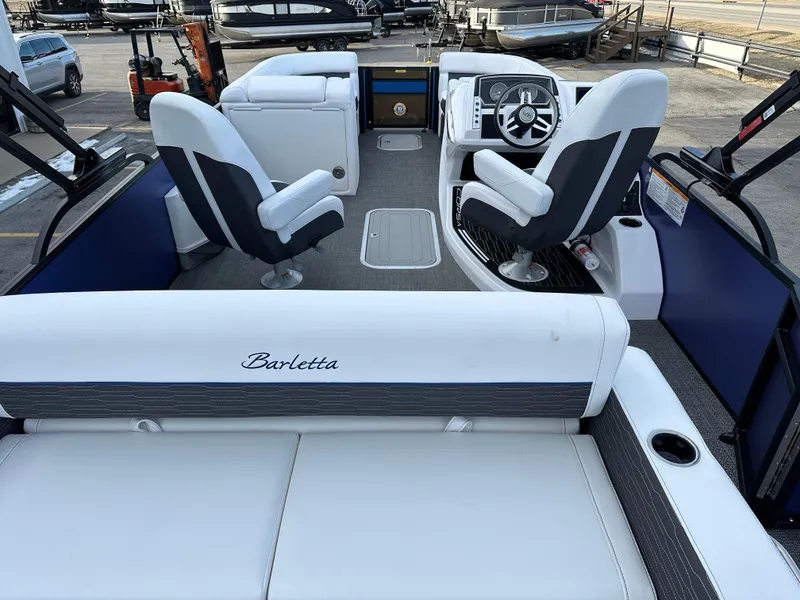 Slide: The Image of 2024 Barletta X23UC boat interior with white seating and modern dashboard. - 14