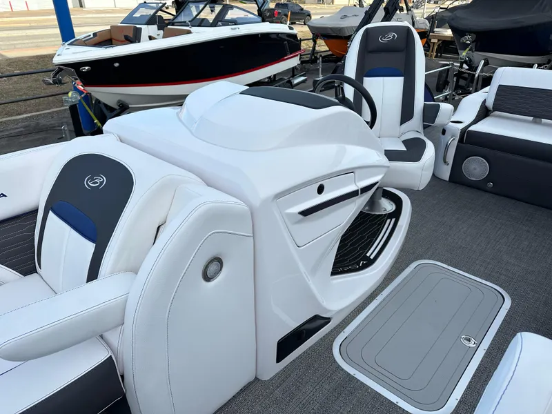 Slide: The Image of 2024 Barletta X23UC boat interior with white and black seating and steering console. - 20
