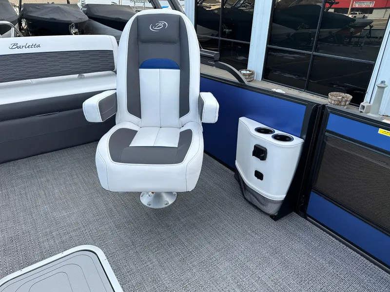 Slide: The Image of 2024 Barletta X23UC boat interior with captain's chair and cup holders. - 21
