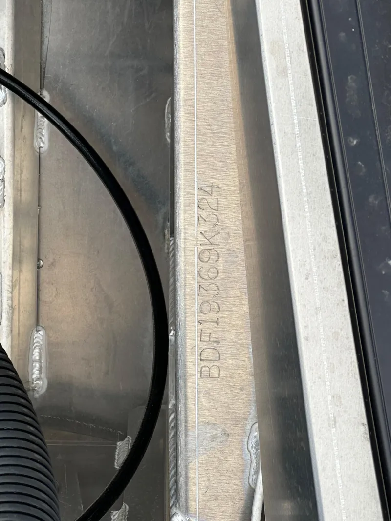 Slide: The Image of Close-up of 2024 Barletta X23UC boat serial number on metal surface. - 23