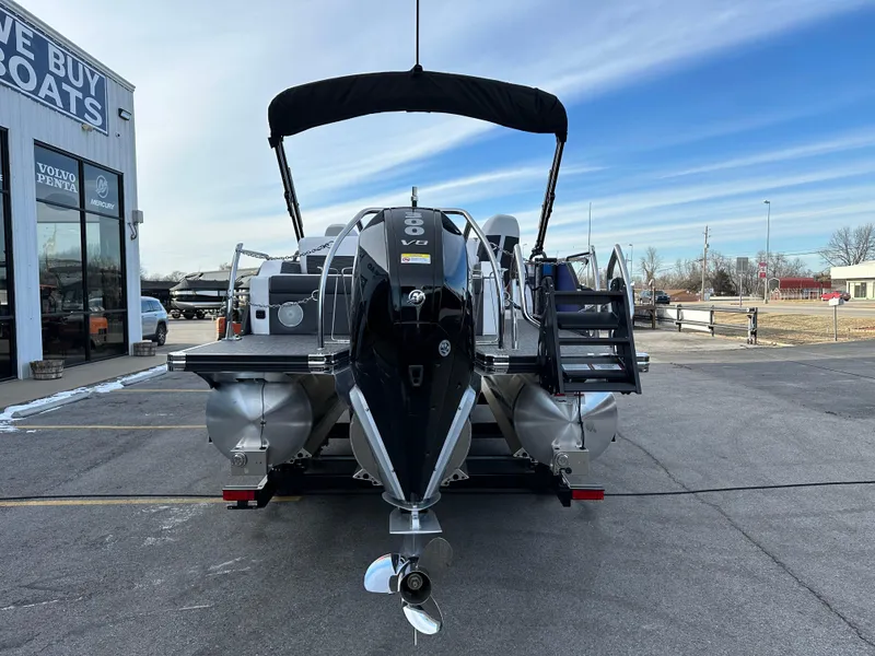 Slide: The Image of 2024 Barletta X23UC pontoon boat with V8 engine, parked outside dealership. - 4