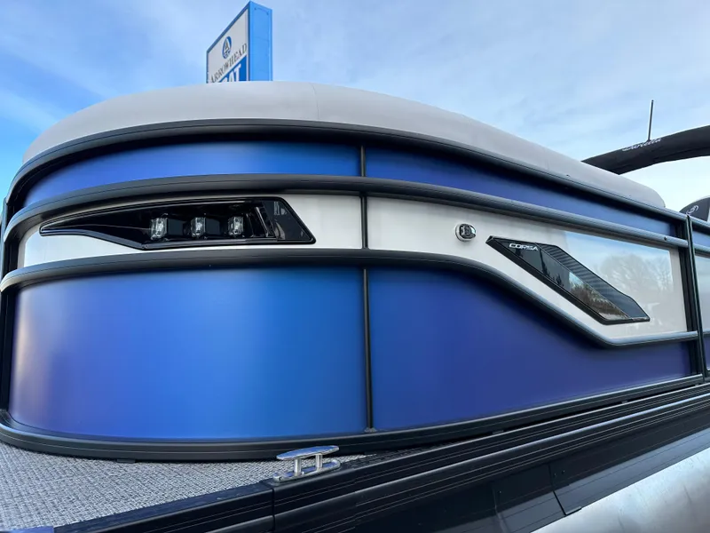 Slide: The Image of 2024 Barletta X23UC pontoon boat with sleek blue and silver design. - 9