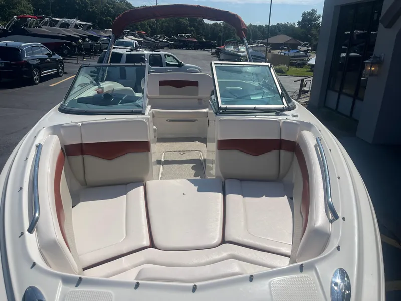 Slide: The Image of 2010 Chaparral 226 boat with spacious seating and open deck in a marina setting. - 10