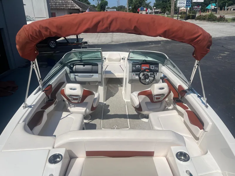 Slide: The Image of 2010 Chaparral 226 boat interior with red canopy and white seating. - 11