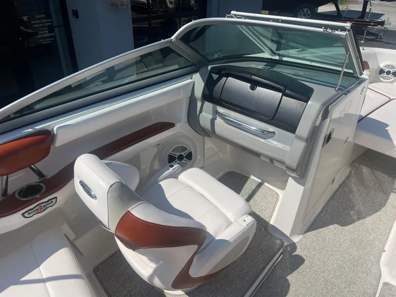 Slide: The Image of Interior of 2010 Chaparral 226 boat with white and brown seating, dashboard, and speakers. - 13