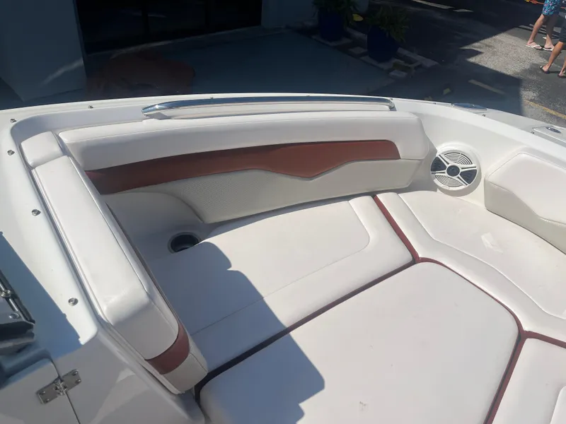 Slide: The Image of 2010 Chaparral 226 boat interior with white and brown seating, speaker, and cup holder. - 18
