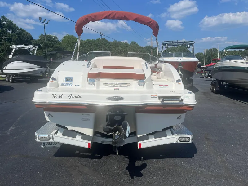 Slide: The Image of 2010 Chaparral 226 boat with red canopy, parked in a marina under blue skies. - 3