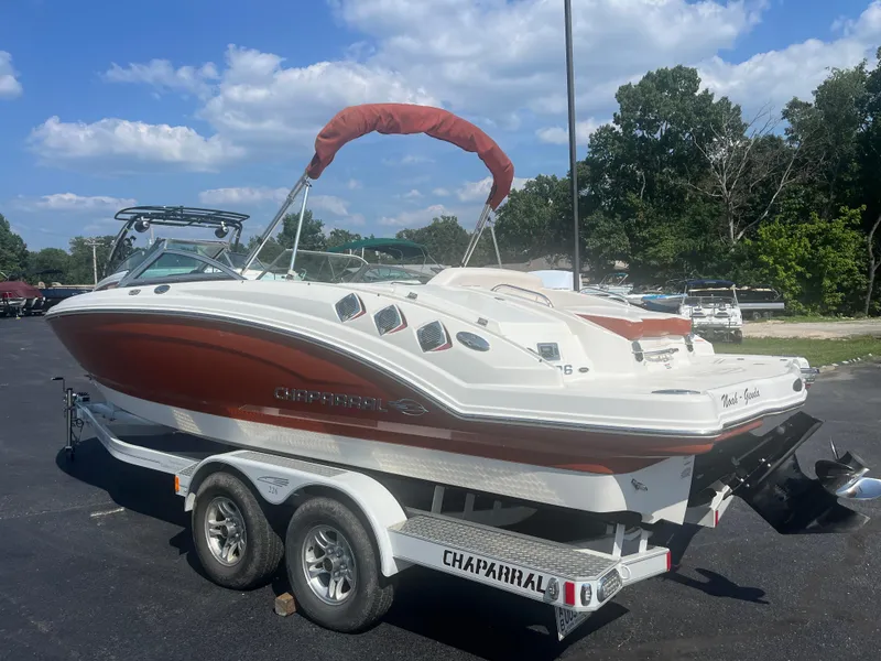 Slide: The Image of 2010 Chaparral 226 boat on trailer, red and white design, parked outdoors. - 4