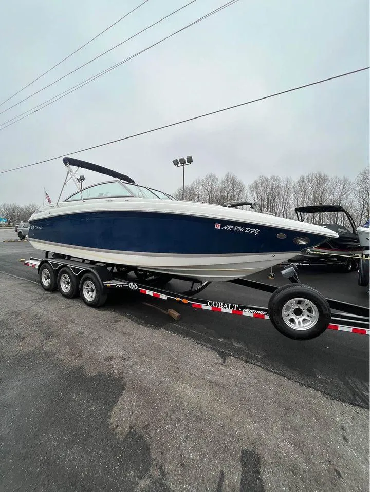 Slide: The Image of 2007 Cobalt 232 boat on trailer, parked outdoors on a cloudy day. - 1