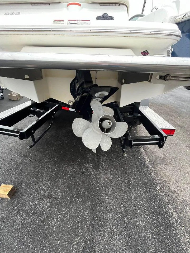 Slide: The Image of 2007 Cobalt 232 boat stern with propeller and trailer on asphalt. - 10
