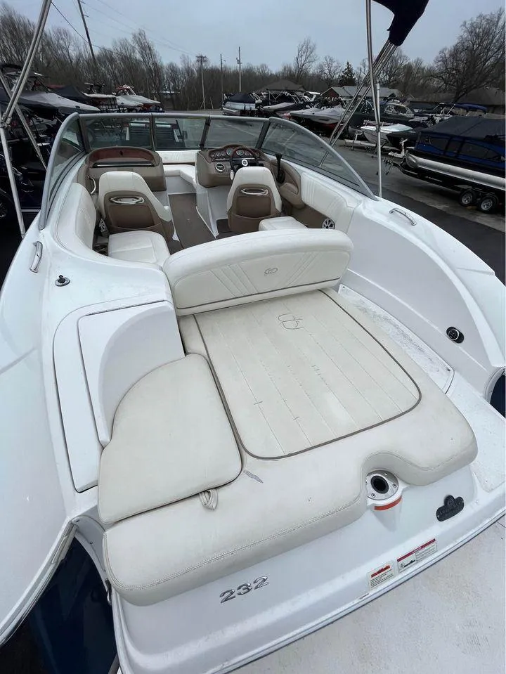 Slide: The Image of 2007 Cobalt 232 boat with white seating and spacious deck, parked in a marina. - 3