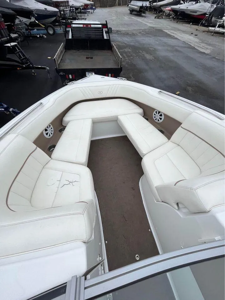 Slide: The Image of 2007 Cobalt 232 boat interior with white seating and speakers, parked on a trailer. - 7