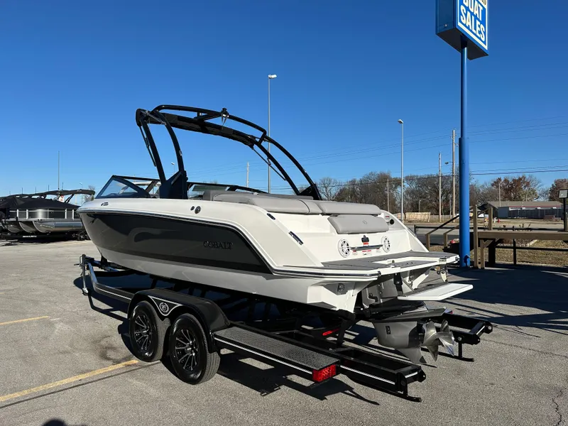 Slide: The Image of 2024 Cobalt CS22 boat on trailer at dealership under clear blue sky. - 6