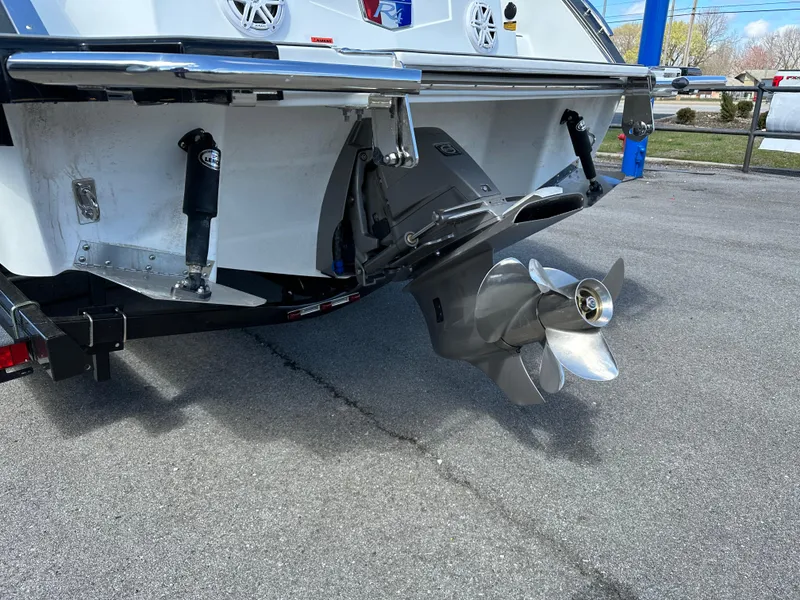 Slide: The Image of 2023 Cobalt R4 boat stern with propeller and trim tabs on pavement. - 6