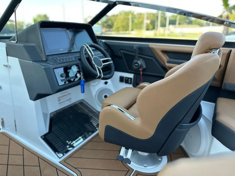 Slide: The Image of 2024 Cobalt R6 boat interior with modern dashboard and tan leather seating. - 19