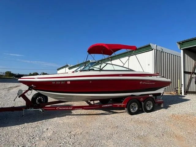 Slide: The Image of 2018 Cownline 225ss boat with red canopy on trailer, parked outdoors. - 15