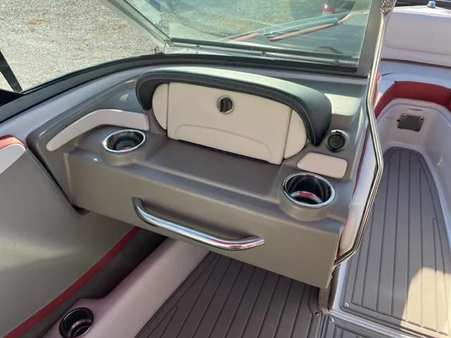 Slide: The Image of 2018 Cownline 225ss boat interior with cup holders and storage compartment. - 7