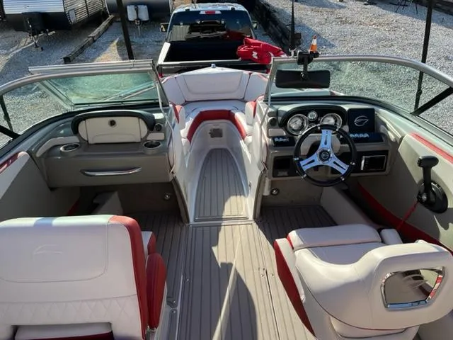 Slide: The Image of 2018 Cownline 225ss boat interior with red and white seating, steering wheel, and dashboard. - 9