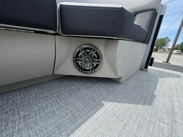 Slide: The Image of 2024 Harris 230CX boat interior with speaker and cushioned seating. - 10