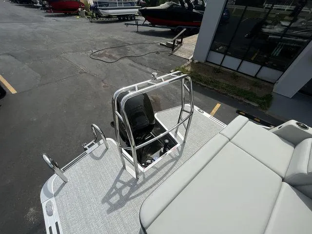 Slide: The Image of 2024 Harris 230CX boat with sleek seating and motor, parked at a marina. - 13