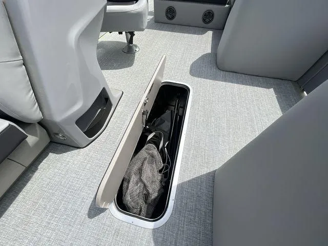 Slide: The Image of 2024 Harris 230CX boat interior with open floor storage compartment. - 21