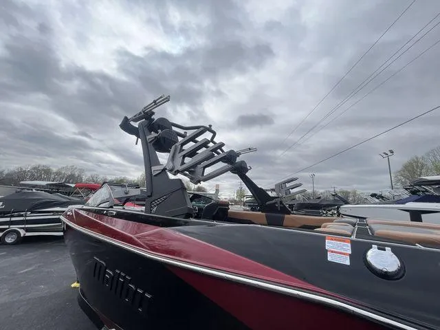 Slide: The Image of 2024 Malibu 23LSV boat with wakeboard racks under cloudy sky. - 10