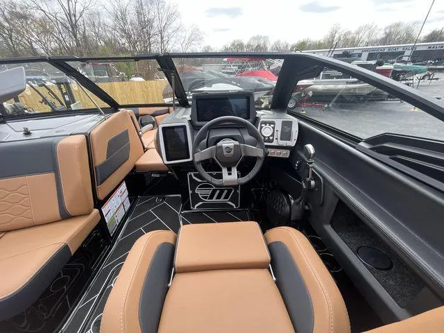 Slide: The Image of 2024 Malibu 23LSV boat interior with modern dashboard and tan seating. - 12