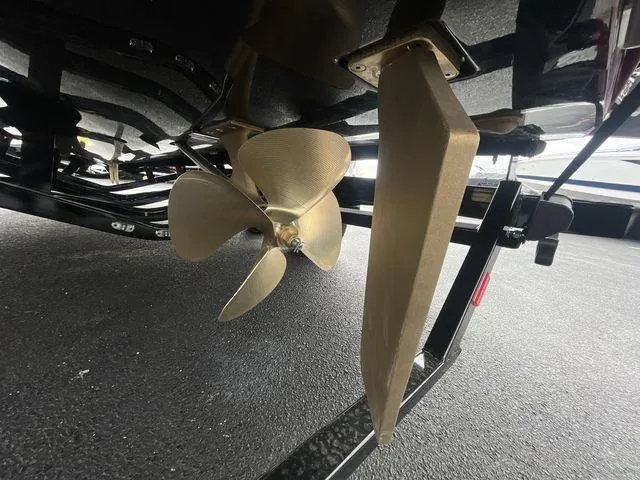 Slide: The Image of 2024 Malibu 23LSV boat propeller and rudder on a trailer. - 16