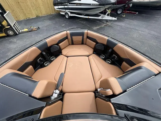 Slide: The Image of 2024 Malibu 23LSV boat interior with tan and black seating. - 17