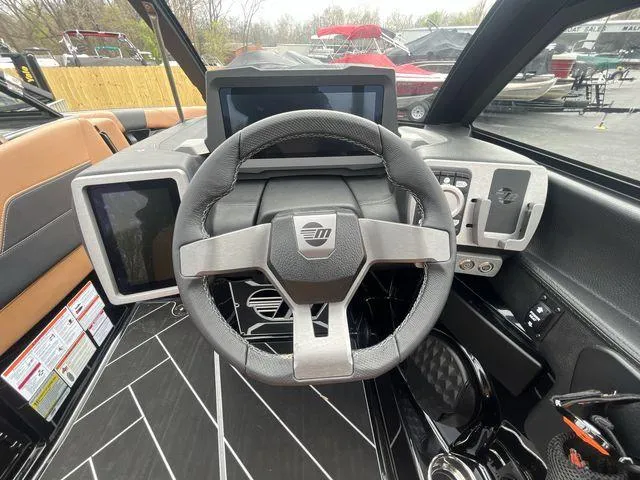 Slide: The Image of 2024 Malibu 23LSV boat dashboard with modern steering wheel and digital displays. - 20