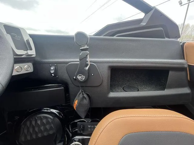 Slide: The Image of 2024 Malibu 23LSV boat interior dashboard with storage compartment and controls. - 3