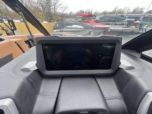 Slide: The Image of 2024 Malibu 23LSV dashboard with touchscreen display, surrounded by boats in a marina. - 5